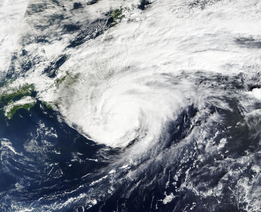 Thematic lead image: flooded street, heavy rain, airport disruption — Japan's Infrastructure Stress Test: Beyond the Local Deluge | National Times