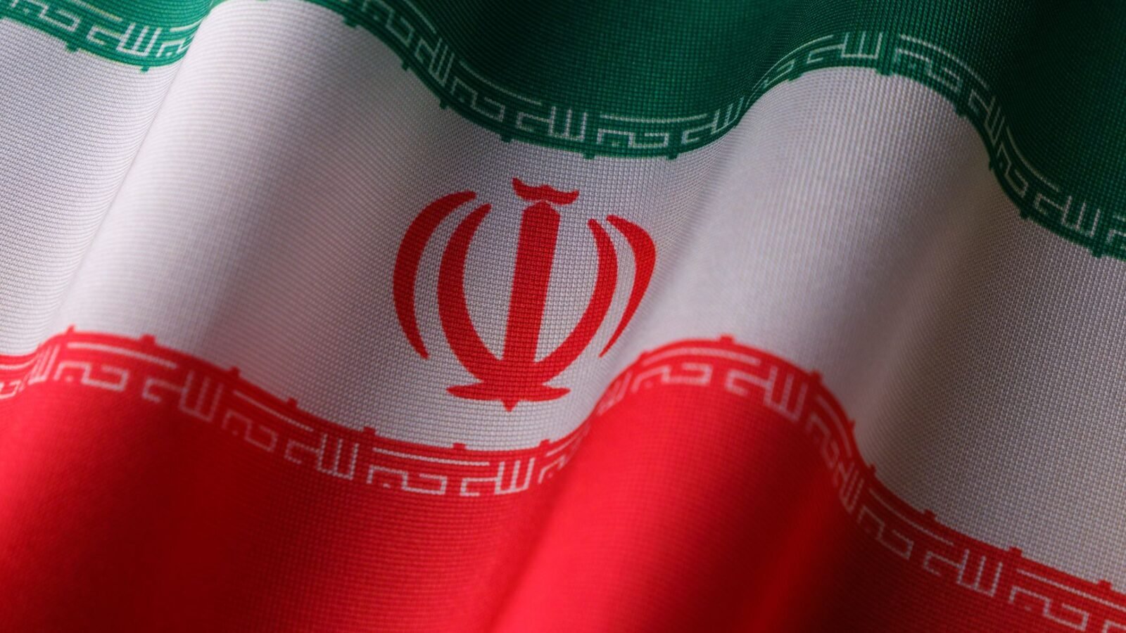 Thematic lead image: Iranian flag, government buildings — Iran's Sanctions Strategy Shifts: Offensive Posture Under US Pressure | National Times