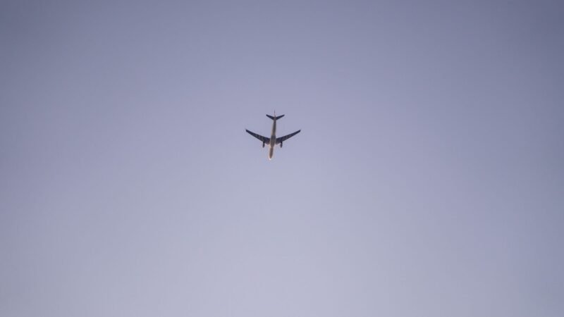 Thematic lead image: aircraft flying over stadium — South African Airlink Stunt Flying Divides Aviation Safety Debate | National Times