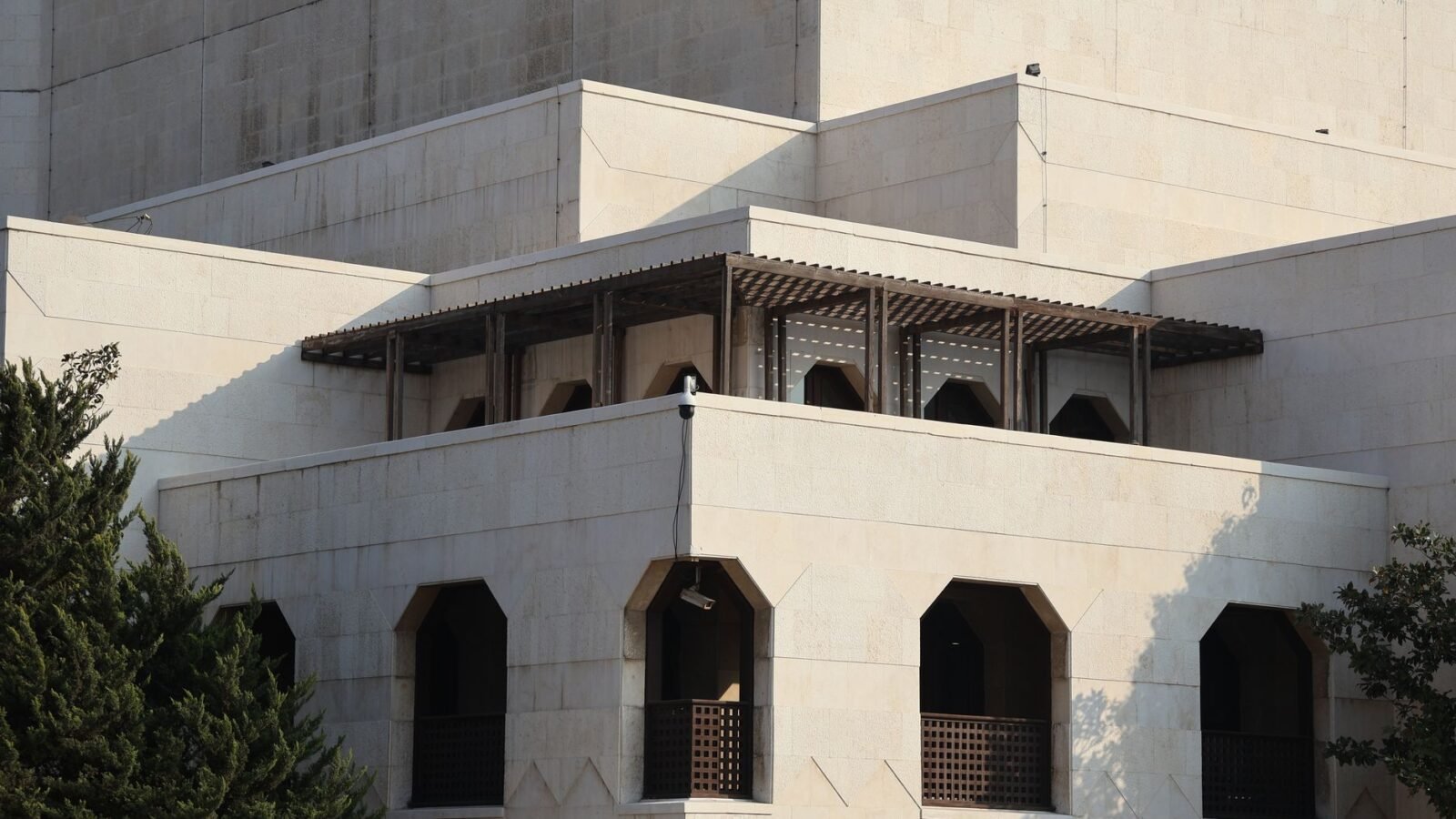 Thematic lead image: Syrian government building — Assad Cousin's Death Sentence Signals Power Consolidation | National Times