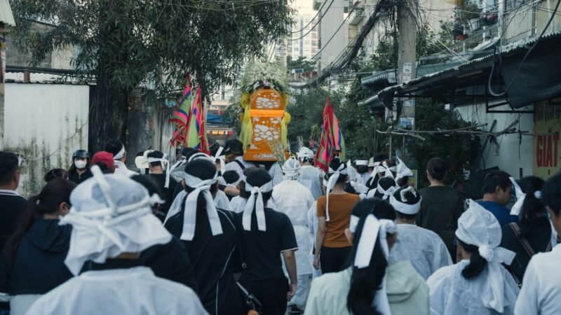 Thematic lead image: mass funeral procession — A Funeral for 112 Is Not One Event. It Is a Process Made Visible | National Times