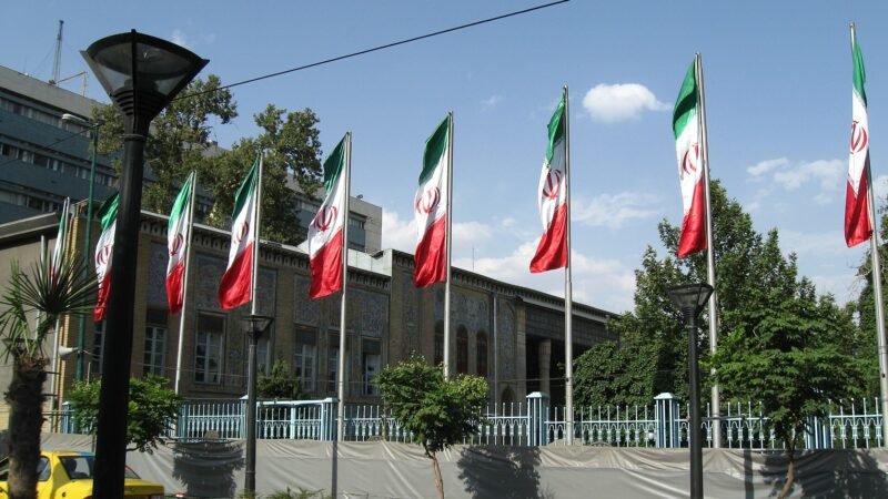 Thematic lead image: Iranian flag, government building — Iran's 'Doomsday War' Rhetoric: Signalling Resolve or Escalation? | National Times